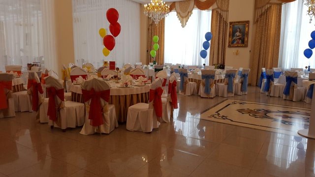 Банкетный зал с красными бантами на стульях